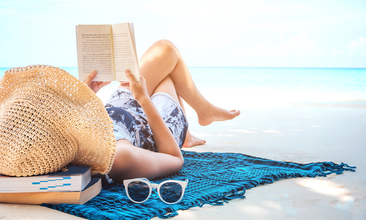 girl reading a book on the beach