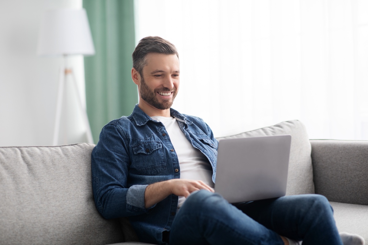 Man smiling while doing something on his computer